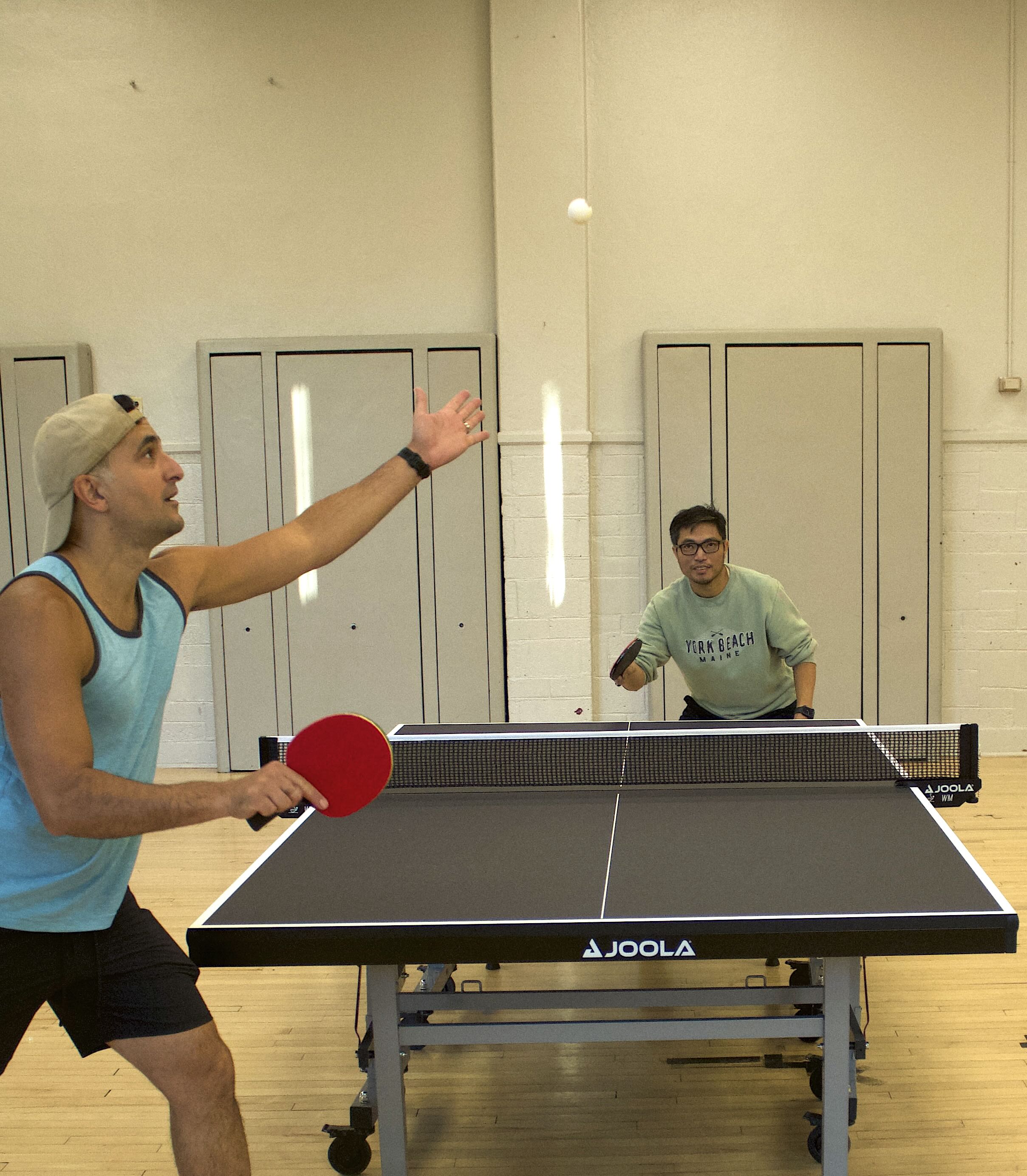 Two players returning a ball during a table tennis match